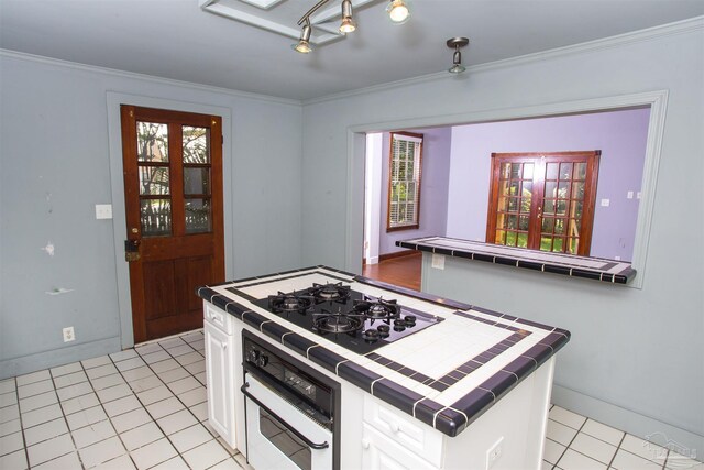 kitchen featuring white cabinetry, crown molding, tile counters, black gas cooktop, and oven