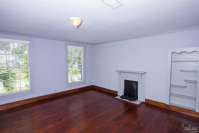 unfurnished living room featuring plenty of natural light and dark hardwood / wood-style floors