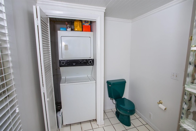 laundry room featuring light tile patterned floors, crown molding, and stacked washing maching and dryer