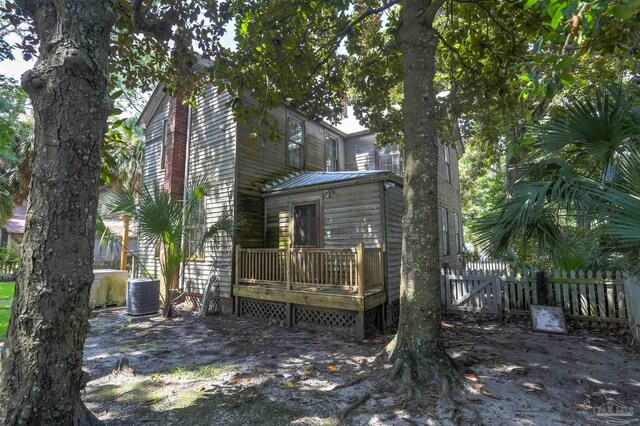 rear view of house with central AC and a deck