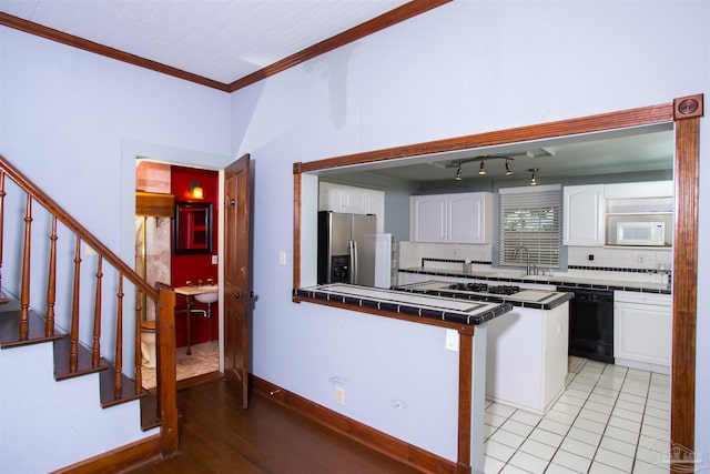 kitchen featuring white appliances, tile countertops, white cabinets, and a kitchen island