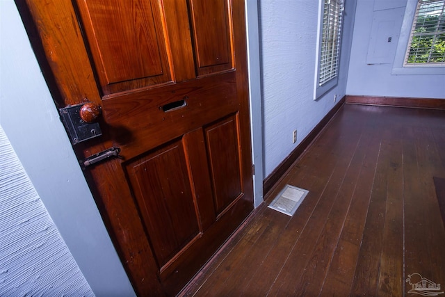 corridor with dark hardwood / wood-style floors and electric panel