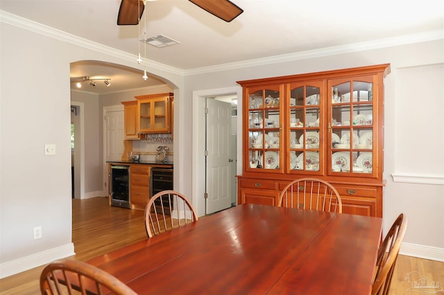 1609 N Spring St, Pensacola, FL 32501 - dining space with wine cooler, arched walkways, ceiling fan, baseboards, and crown molding