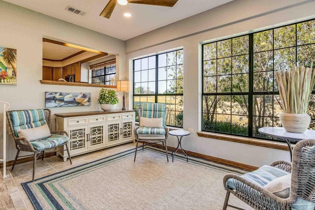 sitting room with ceiling fan and plenty of natural light