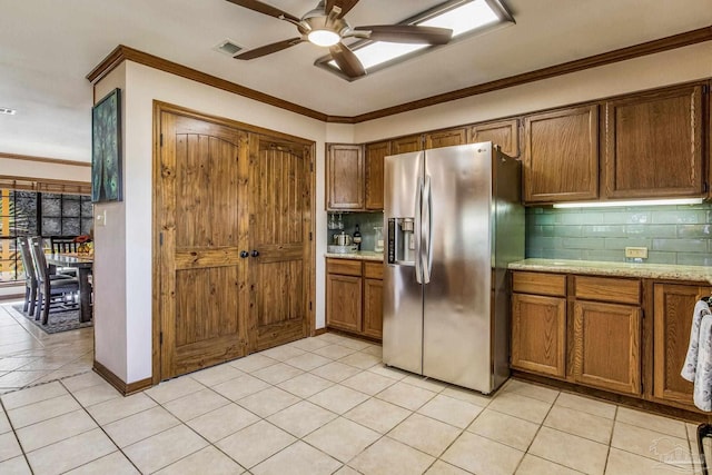 kitchen with stainless steel refrigerator with ice dispenser, backsplash, ornamental molding, ceiling fan, and light tile patterned floors