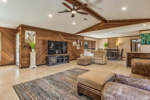 tiled living room featuring wood walls, ceiling fan, lofted ceiling with beams, and a textured ceiling