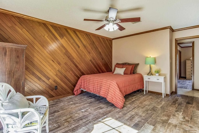 bedroom with ceiling fan, ornamental molding, dark wood-type flooring, and wooden walls