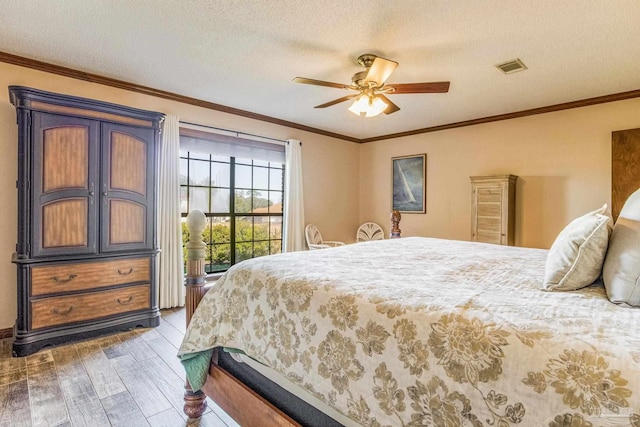 bedroom featuring ceiling fan, wood-type flooring, a textured ceiling, and ornamental molding