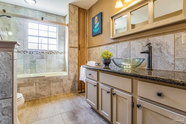 full bathroom featuring vanity, tiled shower / bath combo, tile walls, tile patterned flooring, and toilet