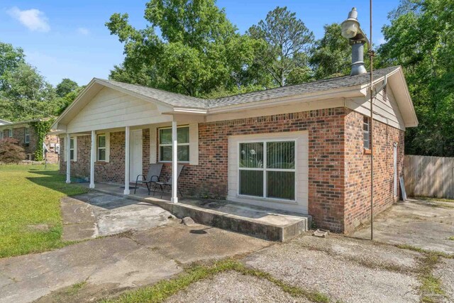 401 Ronda St, Pensacola, FL 32534 - ranch-style home with brick siding, a porch, and roof with shingles