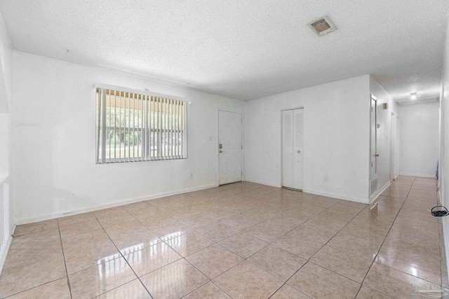 401 Ronda St, Pensacola, FL 32534 - tiled empty room with a textured ceiling and baseboards