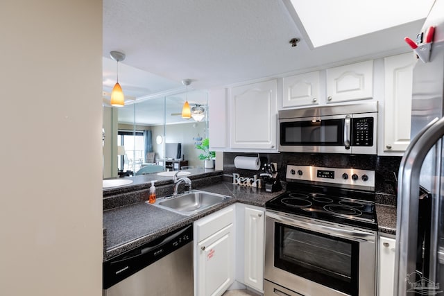 13817 Perdido Key Dr Unit 703, Pensacola, FL 32507 - kitchen with sink, appliances with stainless steel finishes, tasteful backsplash, white cabinets, and decorative light fixtures