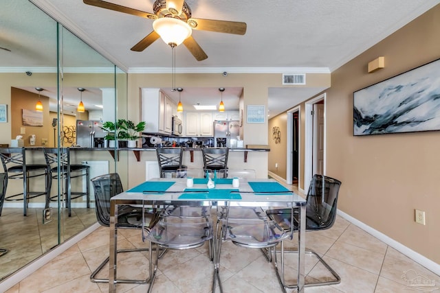 13817 Perdido Key Dr Unit 703, Pensacola, FL 32507 - tiled dining area featuring ceiling fan, ornamental molding, and a textured ceiling