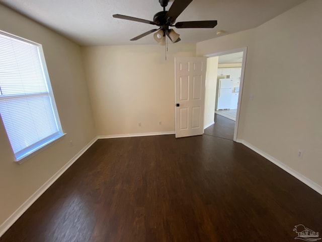 spare room featuring dark hardwood / wood-style flooring and ceiling fan