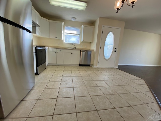 kitchen with white cabinetry, appliances with stainless steel finishes, sink, and light tile patterned floors