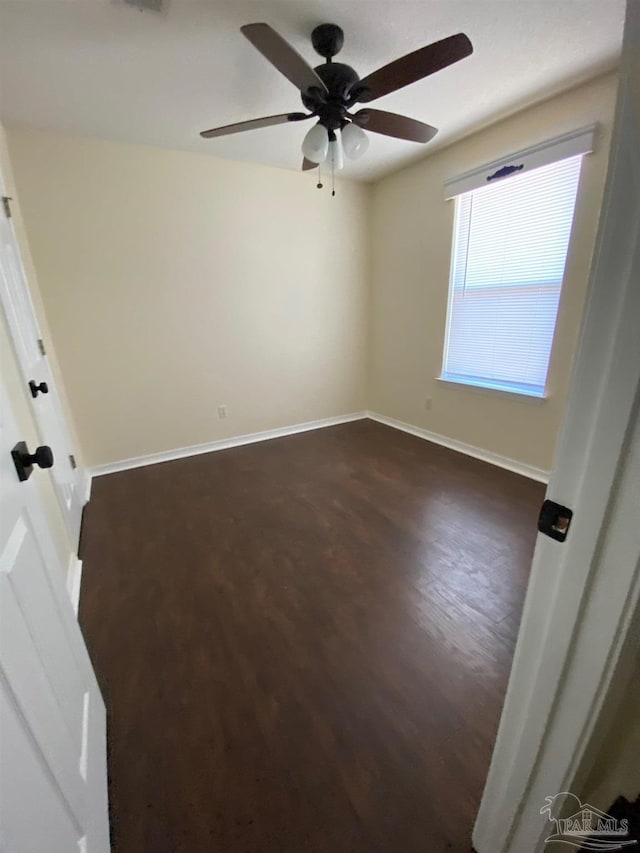 spare room with ceiling fan and dark hardwood / wood-style floors