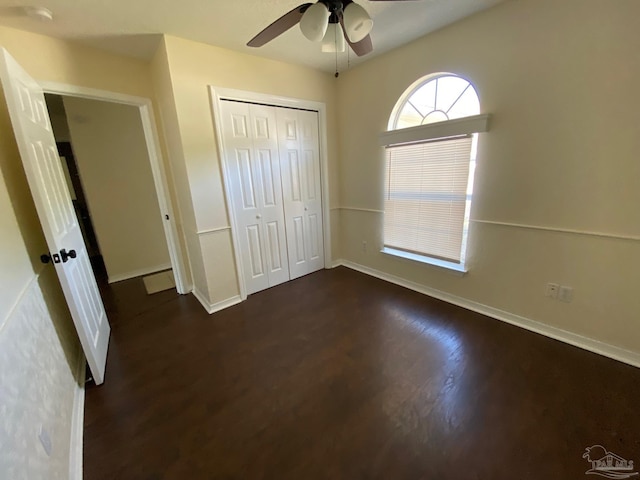 unfurnished bedroom featuring dark wood-type flooring, ceiling fan, and a closet