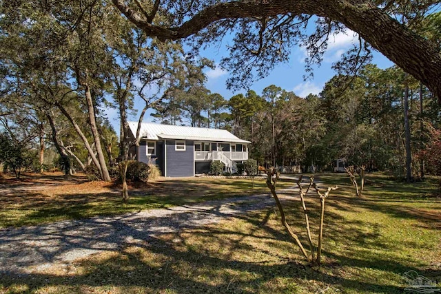 exterior space with a porch, a front yard, and metal roof