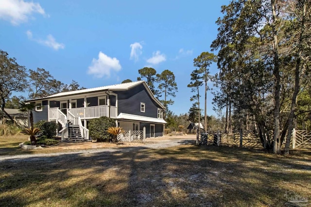 exterior space with a front yard, covered porch, driveway, and stairway