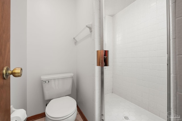 full bathroom with toilet, baseboards, and a stall shower