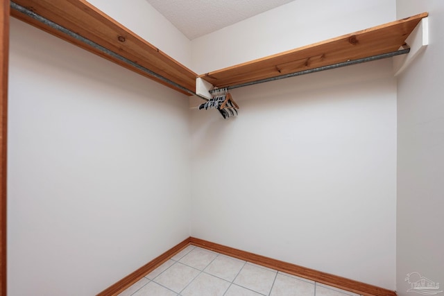 walk in closet with light tile patterned floors