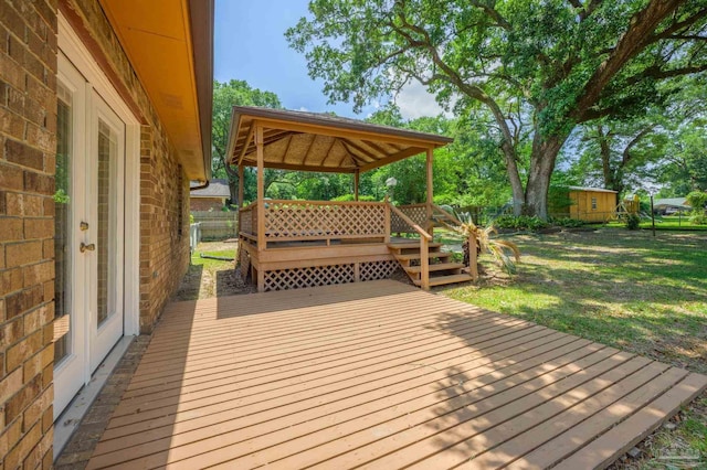 deck with a gazebo, a lawn, and fence