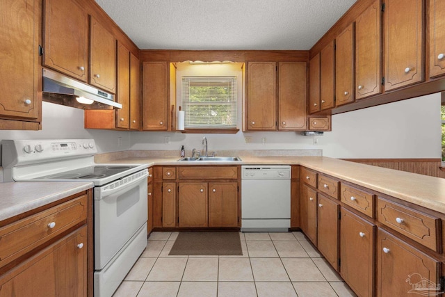kitchen with brown cabinets, a sink, white appliances, light countertops, and under cabinet range hood