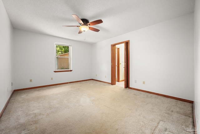 empty room with baseboards, a ceiling fan, carpet flooring, and a textured ceiling