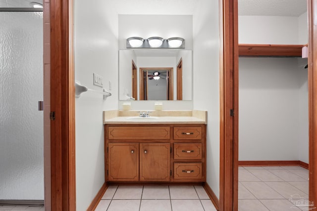 bathroom with tile patterned floors, baseboards, and vanity