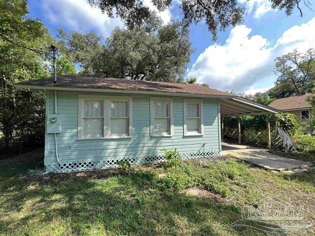 view of side of property featuring a carport and a yard