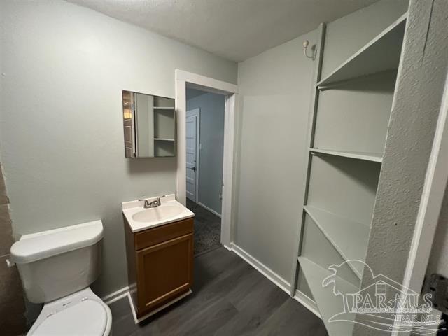 bathroom featuring vanity, hardwood / wood-style floors, and toilet