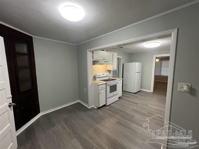 kitchen featuring crown molding, hardwood / wood-style floors, white appliances, and white cabinets