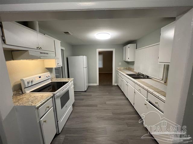 kitchen featuring dark wood-type flooring, white appliances, sink, and white cabinets