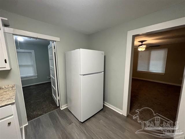 kitchen with white refrigerator, white cabinetry, dark hardwood / wood-style floors, and ceiling fan