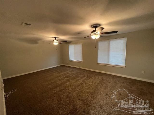 empty room with ceiling fan and dark carpet