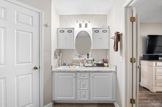 5590 Meadow Creek Pl, Gulf Breeze, FL 32563 - bathroom featuring vanity, a textured ceiling, and wood finished floors
