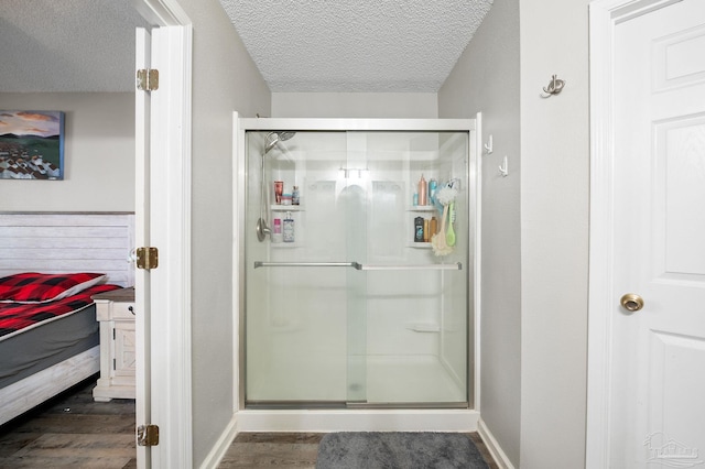 5590 Meadow Creek Pl, Gulf Breeze, FL 32563 - ensuite bathroom with a textured ceiling, wood finished floors, and a stall shower