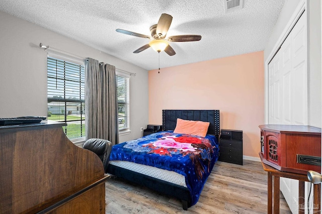 5590 Meadow Creek Pl, Gulf Breeze, FL 32563 - bedroom featuring wood finished floors, a textured ceiling, and ceiling fan