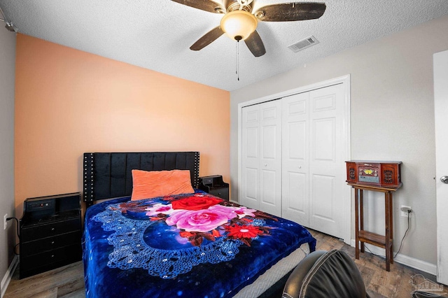 5590 Meadow Creek Pl, Gulf Breeze, FL 32563 - bedroom featuring wood finished floors, a closet, a textured ceiling, and ceiling fan