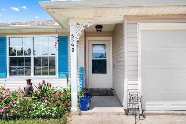 5590 Meadow Creek Pl, Gulf Breeze, FL 32563 - view of exterior entry featuring a garage and roof with shingles