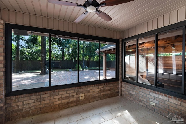 unfurnished sunroom featuring ceiling fan and wood ceiling