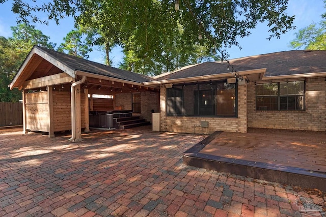 rear view of property featuring a wooden deck and a patio area