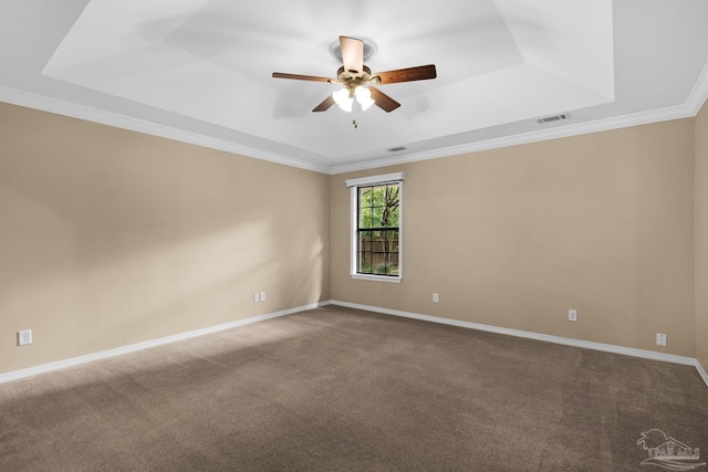 empty room featuring carpet floors, crown molding, a tray ceiling, and ceiling fan