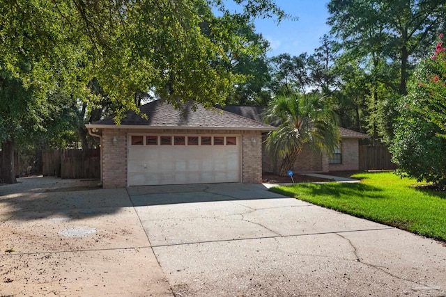 single story home with a garage and a front lawn