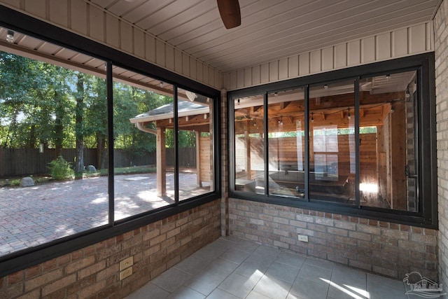 unfurnished sunroom with ceiling fan