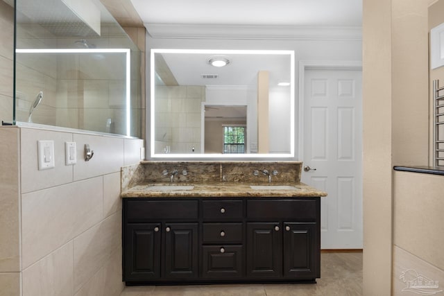 bathroom with vanity, crown molding, a shower with door, and tile patterned floors