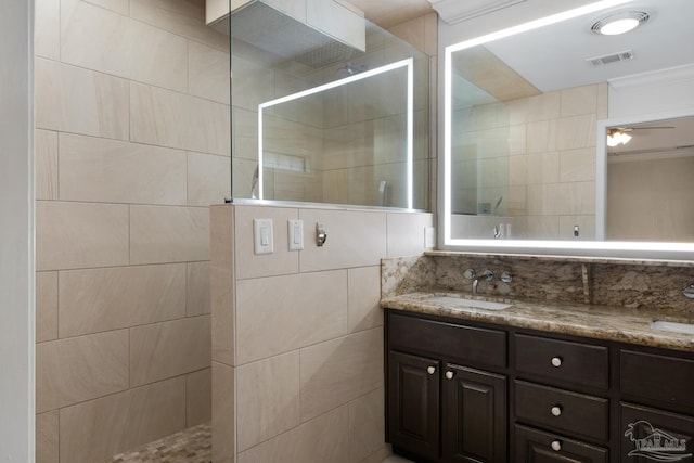 bathroom with crown molding, a shower, vanity, and ceiling fan