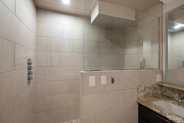 bathroom featuring a tile shower and vanity