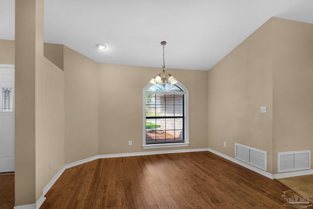 empty room featuring wood-type flooring and a chandelier