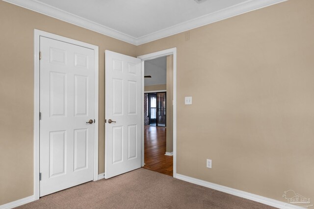 unfurnished bedroom with carpet floors and crown molding